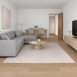 KI-generierte Wohnzimmer-Visualisierung mit grauem Sofa, Essbereich und TV-Möbel